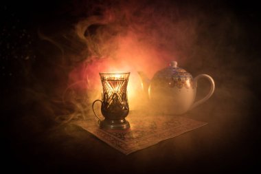Geleneksel glasse ve ışıklar ve duman siyah zemin üzerine pot Doğu tea. Doğu çay kavramı. Armudu geleneksel Azerbaycan/Türkiye Kupası