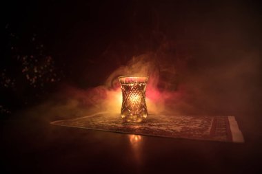 Geleneksel glasse ve ışıklar ve duman siyah zemin üzerine pot Doğu tea. Doğu çay kavramı. Armudu geleneksel Azerbaycan/Türkiye Kupası