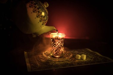 Geleneksel glasse ve ışıklar ve duman siyah zemin üzerine pot Doğu tea. Doğu çay kavramı. Armudu geleneksel Azerbaycan/Türkiye Kupası