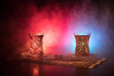 Geleneksel glasse ve ışıklar ve duman siyah zemin üzerine pot Doğu tea. Doğu çay kavramı. Armudu geleneksel Azerbaycan/Türkiye Kupası