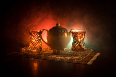 Geleneksel glasse ve ışıklar ve duman siyah zemin üzerine pot Doğu tea. Doğu çay kavramı. Armudu geleneksel Azerbaycan/Türkiye Kupası