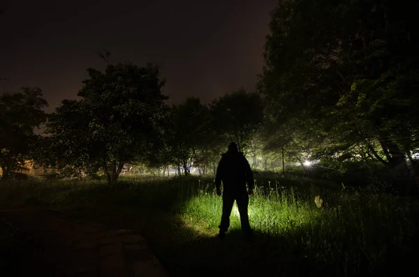 Dziwny sylwetka w ciemnym lesie spooky światłach surrealistyczne nocy, mistyczny krajobraz z creepy człowieka — Zdjęcie stockowe