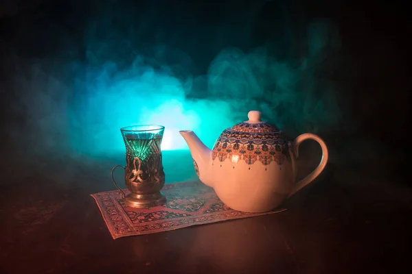 Ostentee in traditionellem Glas und Kanne auf schwarzem Hintergrund mit Licht und Rauch. Eastern Tea Konzept. armudu traditionelle azerbaijan / türkische Tasse — Stockfoto