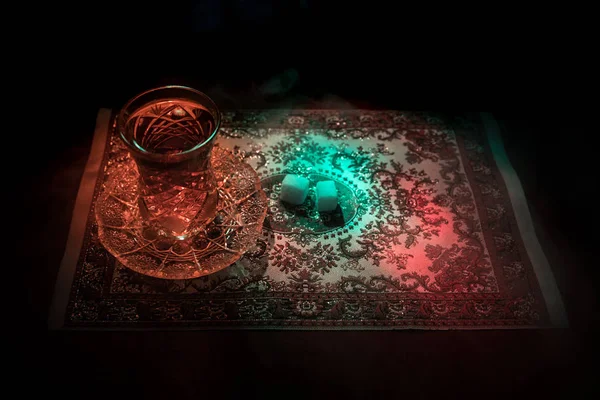 Eastern tea in traditional glasse and pot on black background with lights and smoke. Eastern tea concept. Armudu traditional Azerbaijan/Turkish cup — Stock Photo, Image