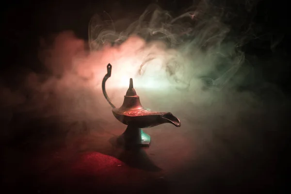 Antique Aladdin arabian nights genie style oil lamp with soft light white smoke, Dark background. Lamp of wishes concept