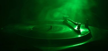 Pikap vinil plak çalar. Retro ses ekipmanları için disk jokey. Dj mix ve müzik çalmak için ses teknolojisi. Yangın arka plan yanan karşı oynanan vinil kaydı