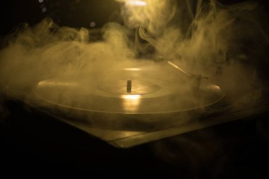 Pikap vinil plak çalar. Retro ses ekipmanları için disk jokey. Dj mix ve müzik çalmak için ses teknolojisi. Yangın arka plan yanan karşı oynanan vinil kaydı