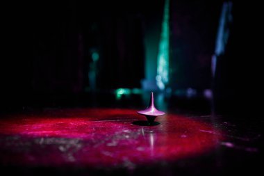 Totem iplik üst iplik, wobbling ve durdurma. Üst tonda duman arka ışıklı ayna yüzeyinde iplik. Eğlenceyi eylem masada karanlık odada.