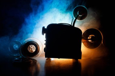 Eski stil film projektör, yakın çekim. Film projektör dramatik aydınlatma ve seçici odak ahşap bir zemin üzerine. Film ve eğlence kavramının