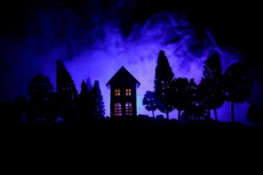 Eski ev gece ormanda bir hayalet veya siste perili korku evi terk etti. Ölü ağaç orman eski mistik binada. Ağaçlar moon ile gece. Gerçeküstü ışıklar