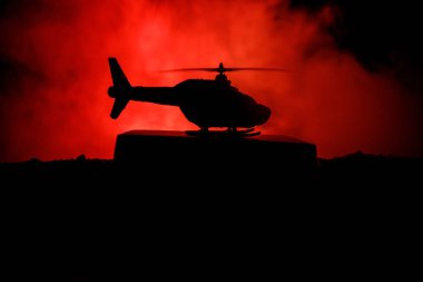 Askeri helikopter çatışma bölgesinden uçmaya hazır silüeti. Gece görüntüleri çöl sisli tonda sırt ile başlayarak helikopter ile dekore edilmiştir. Seçici odak.