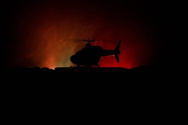 Askeri helikopter çatışma bölgesinden uçmaya hazır silüeti. Gece görüntüleri çöl sisli tonda sırt ile başlayarak helikopter ile dekore edilmiştir. Seçici odak.