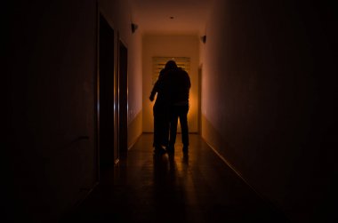 Kabine kapılar ve korkunç korku adam ile farklı pozlar ayakta silüeti ışıklarla karanlık koridor.