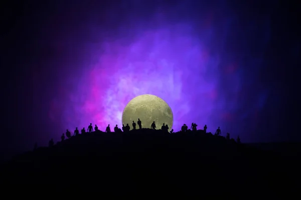 Vue effrayante foule de zombies sur la colline avec ciel nuageux effrayant avec brouillard et pleine lune montante. Groupe de silhouette de zombie marchant sous la pleine lune . — Photo