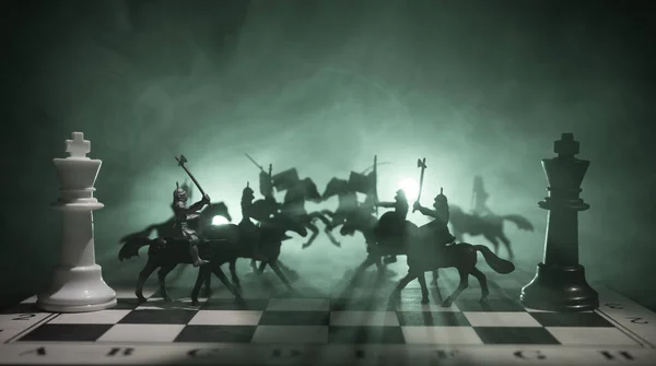 Scena de luptă medievală cu cavalerie și infanterie pe tabla de șah. Conceptul de joc de șah al ideilor de afaceri și al ideilor de concurență și strategie Cifrele de șah pe un fundal întunecat. Focalizare selectivă — Fotografie, imagine de stoc