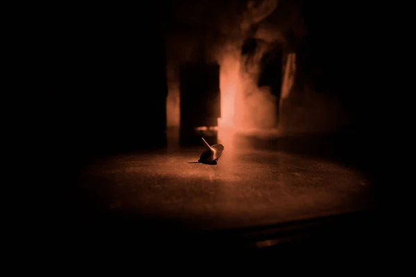 Tótem girando la parte superior girando, oscilando y deteniéndose. Tapa giratoria en la superficie del espejo con luz de fondo de humo tonificada. Whirligig en acción en cuarto oscuro en la mesa . — Foto de Stock