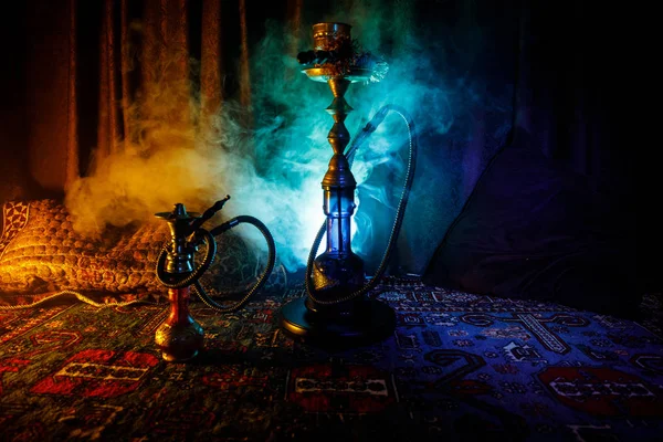 Hookah carbones calientes en el tazón de shisha haciendo nubes de vapor en el interior de Arabia. Adorno oriental en la alfombra. Elegante shisha oriental en la oscuridad con contraluz. Para el anuncio de Shisha — Foto de Stock