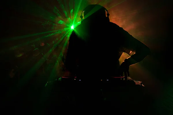 DJ Spinning, Mixing, and Scratching in a Night Club, Hands of dj tweak vari controlli delle tracce sul ponte del DJ, luci stroboscopiche e nebbia, o Dj mixa la traccia nel nightclub alla festa — Foto Stock