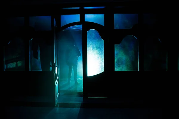 Sylwetka figura nieznany cień na drzwi, przez zamknięte drzwi. Sylwetka człowieka przed oknem w nocy. Koncepcja halloween przerażające sceny nieostre sylwetki — Zdjęcie stockowe