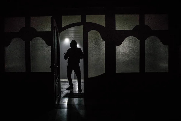 Απεικόνισή του ένα σχήμα άγνωστο σκιά σε μια πόρτα μέσα από μία κλειστή γυάλινη πόρτα. Η σιλουέτα ενός ανθρώπου μπροστά από ένα παράθυρο τη νύχτα. Τρομακτική σκηνή Απόκριες έννοια της θολή σιλουέτα — Φωτογραφία Αρχείου