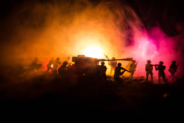 War Concept. Military silhouettes fighting scene on war fog sky background, World War Soldiers Silhouettes Below Cloudy Skyline At night. Attack scene. Armored vehicles. Tanks battle.
