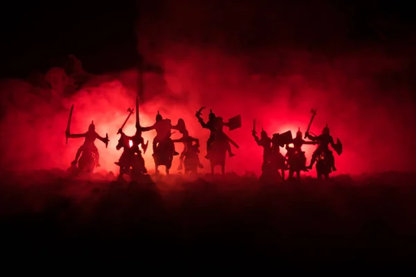 Escena de batalla medieval con caballería e infantería. Siluetas de figuras como objetos separados, lucha entre guerreros sobre fondo de niebla tonificado oscuro. Escena nocturna . —  Fotos de Stock