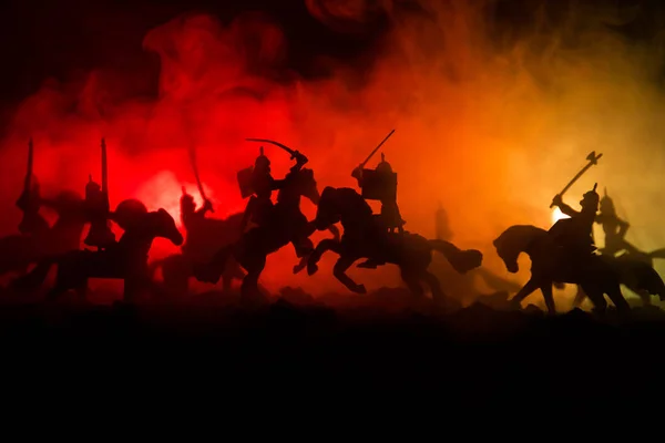Középkori harci jelenet, a lovasság és a gyalogság. Sziluettek számok külön objektumokként küzdelem között a sötét tónusú ködös háttér harcosok. Éjszakai élet. — Stock Fotó
