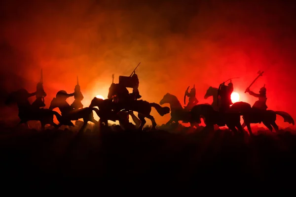 Középkori harci jelenet, a lovasság és a gyalogság. Sziluettek számok külön objektumokként küzdelem között a sötét tónusú ködös háttér harcosok. Éjszakai élet. — Stock Fotó