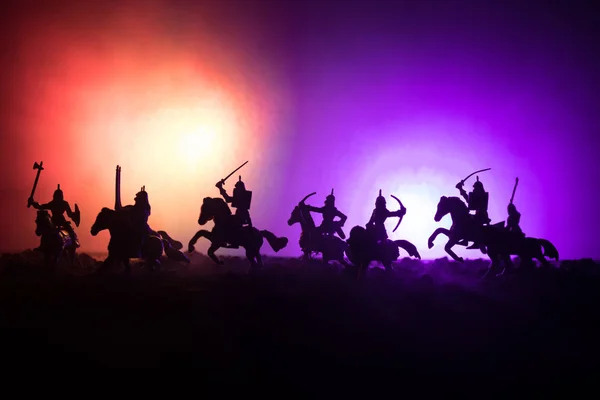 Cena de batalha medieval com cavalaria e infantaria. Silhuetas de figuras como objetos separados, luta entre guerreiros em fundo enevoado escuro. Cena noturna . — Fotografia de Stock