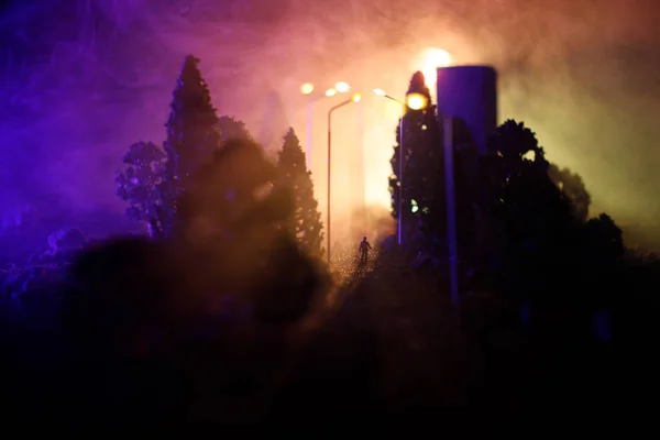 Stadt bei Nacht im dichten Nebel. Dichter Smog auf einer dunklen Straße. Silhouetten von Menschen auf der Straße. Tischdekoration. Selektiver Fokus — Stockfoto