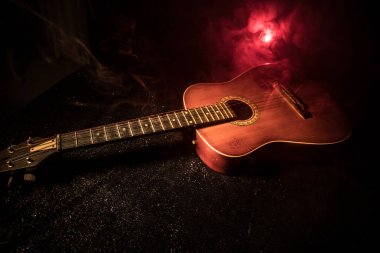 Müzik konsepti. Akustik gitar duman ile ışık altında karanlık bir arka plan üzerinde. Gitar dizeleri ile kapatın. Seçici odak. Etkileri ateş. Gerçeküstü gitar