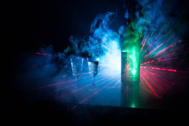 İki kadeh votka şişesiyle karanlık sisli parlayan ışıklar (lazer, Stobe) çok renkli stil arka plan kulübü. Kulüp tema dekorasyon içer. Boş alanı. Seçici odak