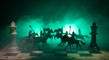 Süvari ve satranç tahtası üzerinde piyade ile ortaçağ savaş sahnesi. Satranç oyununu kavramı iş fikirleri ve rekabet ve strateji fikirler duman ve sis karanlık bir arka plan üzerinde satranç figürleri.