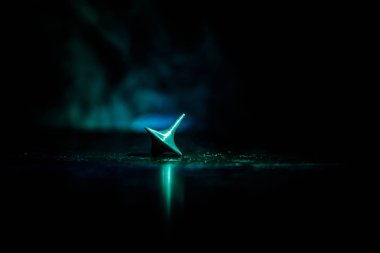 Totem iplik üst iplik, wobbling ve durdurma. Üst tonda duman arka ışıklı ayna yüzeyinde iplik. Eğlenceyi eylem masada karanlık odada. Seçici odak