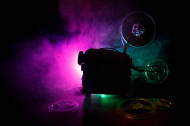 Eski stil film projektör, Natürmort, yakın çekim. Film projektör dramatik aydınlatma ve seçici odak ahşap bir zemin üzerine. Film ve eğlence kavramının