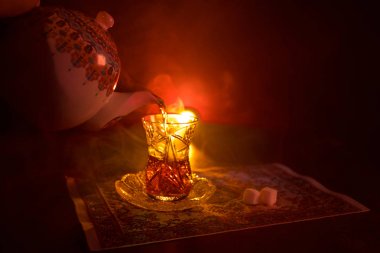 Geleneksel glasse ve ışıklar ve duman siyah zemin üzerine pot Doğu tea. Doğu çay kavramı. Armudu geleneksel Azerbaycan/Türkiye Kupası. Seçici odak. Bardak çay