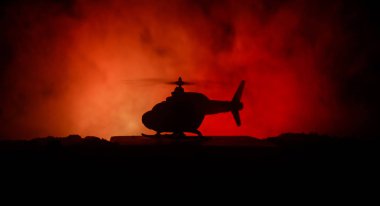 Askeri helikopter çatışma bölgesinden uçmaya hazır silüeti. Gece görüntüleri çöl sisli tonda sırt ile başlayarak helikopter ile dekore edilmiştir. Seçici odak.