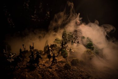 Süvari ve piyade ile ortaçağ savaş sahnesi. Siluetleri şekiller ayrı nesneler olarak mücadele koyu tonda sisli arka plan savaşçılar arasında. Gece çekimi.