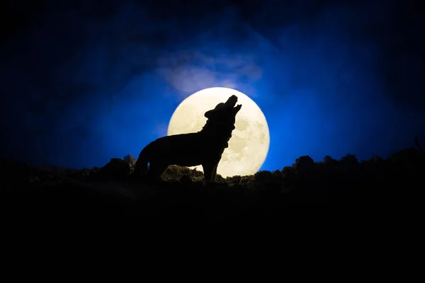 対ダーク ハウリング狼のシルエットは 満月にハウリング シルエットの霧の背景と満月やオオカミをトーンダウンしました ハロウィーン ホラー コンセプト 選択と集中 — ストック写真