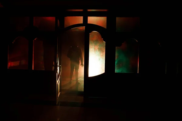 Silhouette of an unknown shadow figure on a door through a closed glass door. The silhouette of a human in front of a window at night. Scary scene halloween concept of blurred silhouette — Stock Photo, Image