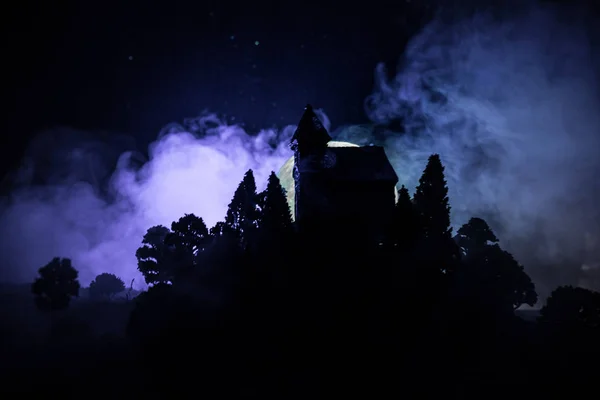 Antigua casa con un Fantasma en el bosque por la noche o Casa de terror embrujada abandonada en la niebla. Antiguo edificio místico en el bosque de árboles muertos. concepto de Halloween horror. — Foto de Stock