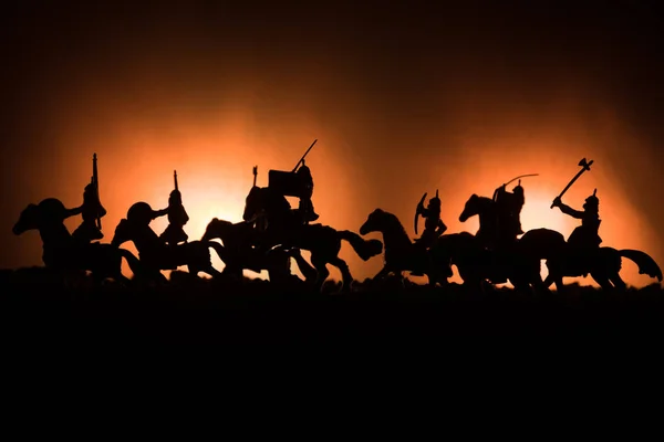 Cena de batalha medieval com cavalaria e infantaria. Silhuetas de figuras como objetos separados, luta entre guerreiros em fundo enevoado escuro. Cena noturna . — Fotografia de Stock