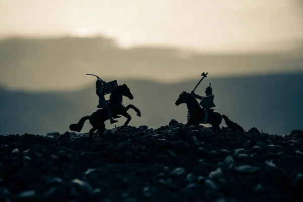 Utkat se mezi dvěma rytíři na koních. Západ slunce na pozadí. Selektivní fokus — Stock fotografie