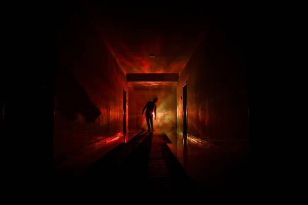 Silueta espeluznante en el oscuro edificio abandonado. Corredor oscuro con puertas de gabinete y luces con silueta de espeluznante persona de horror de pie con diferentes poses . —  Fotos de Stock