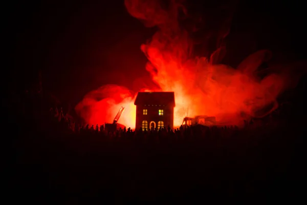 Enorme Chama Distraindo Casa em Fogo. Motor de bombeiros com escada e bombeiro tentando salvar a casa. Bombeiro no trabalho. Conceito de segurança contra incêndio . — Fotografia de Stock