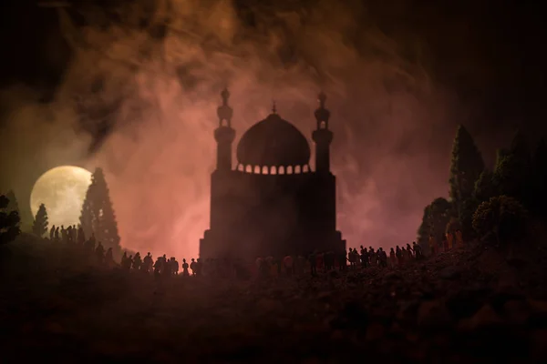 Силует великий натовп людей в лісі в нічний стоячи проти розмиті мечеть будівля з тонованими світлових потоків на Туманний фону. Рамадан Карім фону. — стокове фото