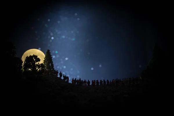 상승 큰 보름달을 보고 밤에 숲에서 사람들의 큰 군중의 실루엣. 배경 별, 밤하늘을 장식 문 및 공간 요소. 선택적 초점. — 스톡 사진