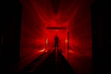 Ürpertici siluet koyu terk edilmiş binada. Manyak genel kavram ya da kabine kapılar ile karanlık koridor ve ışıkları ile farklı pozlar duran korkunç korku kişi silueti ile ilgili korku.