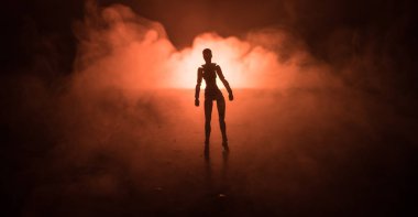Üzerinde bir karanlık sisli tonlu arka plan ayakta adam silüeti. Işıklı masada adam figürü ile dekore edilmiş fotoğraf. Seçici odak
