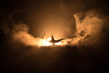 Dilek ve lamba. Dilek sisli arka plan üzerinde tonda ışık ışınları ile büyük bir lamba karşı duran insanlar, büyük bir kalabalık silüeti. Karanlık gece masa dekorasyonu. Seçici odak